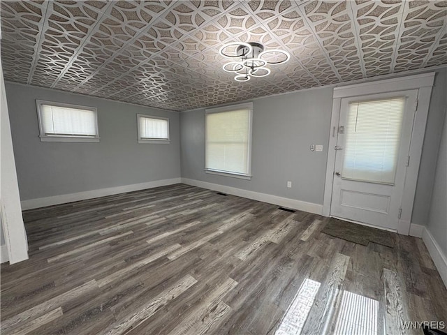 354 Schenck St, North Tonawanda, NY 14120 - unfurnished dining area with an ornate ceiling, baseboards, and dark wood-style flooring