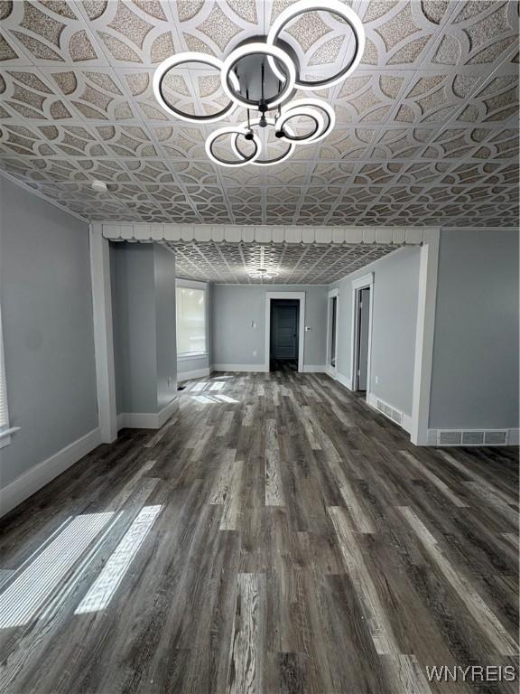 354 Schenck St, North Tonawanda, NY 14120 - unfurnished living room with an ornate ceiling, baseboards, wood finished floors, and a chandelier