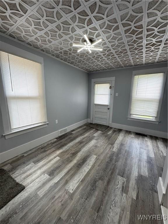 354 Schenck St, North Tonawanda, NY 14120 - unfurnished living room with baseboards, an ornate ceiling, and wood finished floors