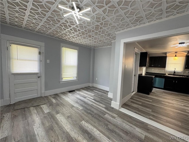 354 Schenck St, North Tonawanda, NY 14120 - kitchen with an ornate ceiling, plenty of natural light, baseboards, dark cabinets, and wood finished floors