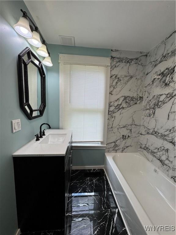 354 Schenck St, North Tonawanda, NY 14120 - full bathroom featuring marble tiled floors, vanity, a bath, and baseboards