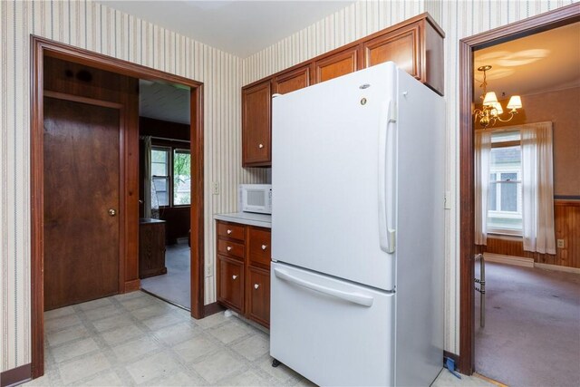 376 Imperial Ave, Erwin, NY 14870 - kitchen with white appliances, wallpapered walls, a chandelier, light floors, and brown cabinets