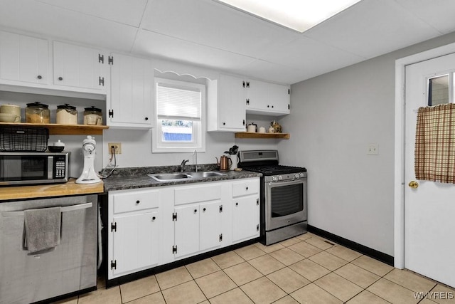 10652 Elm St, North Collins, NY 14111 - kitchen featuring stainless steel appliances, open shelves, a sink, dark countertops, and a paneled ceiling