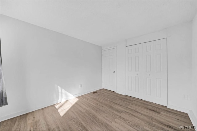 8 Robin Rd, Amherst, NY 14228 - unfurnished bedroom with wood finished floors, a closet, and baseboards