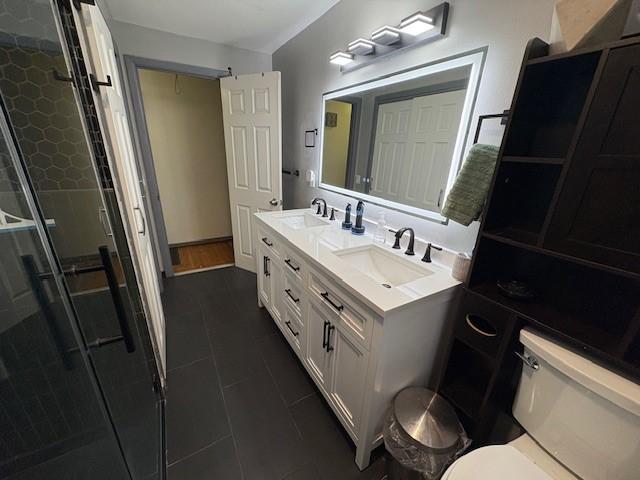 245 Weaver St, Rochester, NY 14621 - bathroom with double vanity, a stall shower, tile patterned flooring, and toilet