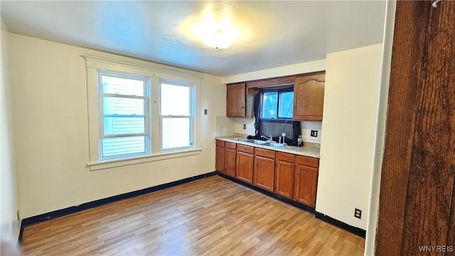 341 Dartmouth Ave, Buffalo, NY 14215 - kitchen featuring light countertops, light wood-style flooring, baseboards, and brown cabinets