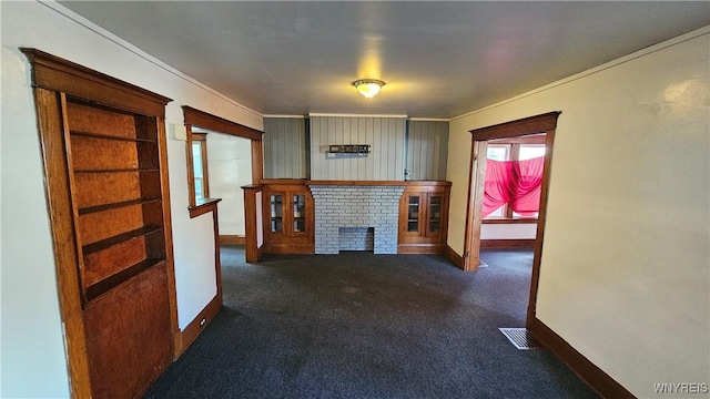 341 Dartmouth Ave, Buffalo, NY 14215 - unfurnished living room with baseboards, a brick fireplace, ornamental molding, and dark colored carpet