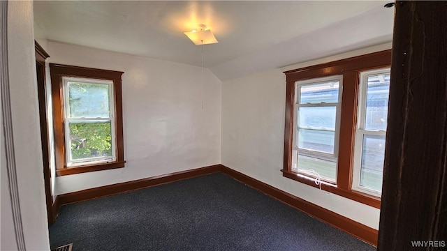 341 Dartmouth Ave, Buffalo, NY 14215 - unfurnished room featuring baseboards, plenty of natural light, vaulted ceiling, and dark carpet