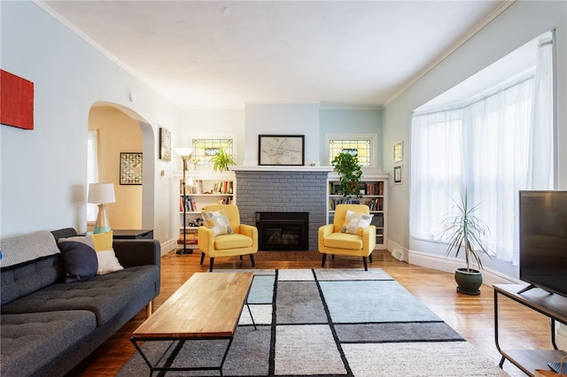 43 Woodland Park, Rochester, NY 14610 - living area with wood finished floors, a fireplace, ornamental molding, arched walkways, and baseboards