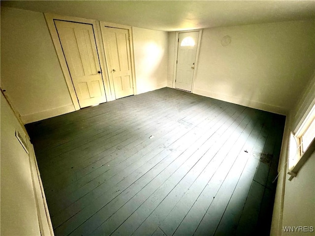 6723 Akron Rd, Lockport Town, NY 14094 - unfurnished bedroom with dark wood-type flooring