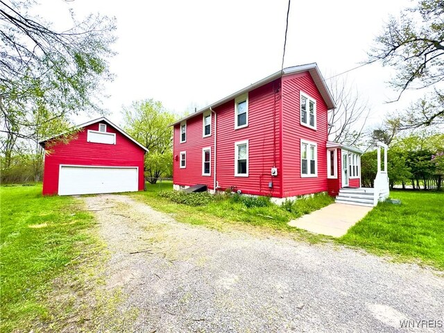 6723 Akron Rd, Lockport Town, NY 14094 - view of side of home featuring an outdoor structure, a garage, and a lawn