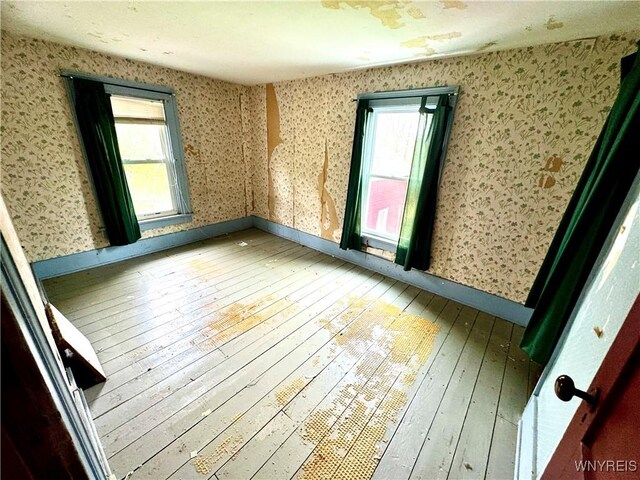 6723 Akron Rd, Lockport Town, NY 14094 - spare room featuring hardwood / wood-style floors, wallpapered walls, and baseboards