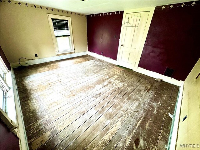 6723 Akron Rd, Lockport Town, NY 14094 - unfurnished bedroom featuring wood-type flooring and baseboards