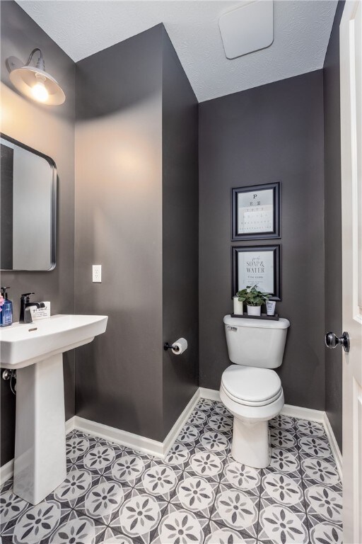 8 Colten Ct, Penfield, NY 14580 - half bath with toilet, baseboards, tile patterned floors, and a sink