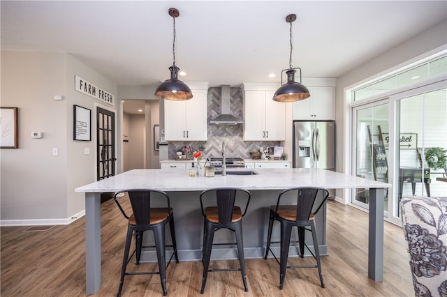 8 Colten Ct, Penfield, NY 14580 - kitchen featuring wall chimney exhaust hood, stainless steel fridge, white cabinetry, a large island, and backsplash
