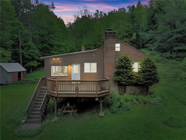 543 Middlefield Rd, Westford, NY 12155 - back of house at dusk with a deck, a yard, a chimney, stairway, and a view of trees