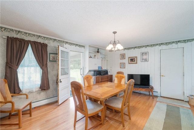 9 N Clinton St, North Dansville, NY 14437 - dining space featuring plenty of natural light, a chandelier, light wood-style flooring, a textured ceiling, and crown molding