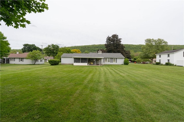 9 N Clinton St, North Dansville, NY 14437 - rear view of property with a lawn, a sunroom, and a chimney