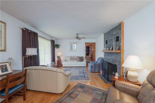 9 N Clinton St, North Dansville, NY 14437 - living area with light wood finished floors, ceiling fan, and a stone fireplace
