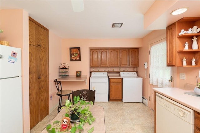 9 N Clinton St, North Dansville, NY 14437 - kitchen featuring white appliances, washing machine and clothes dryer, light countertops, a baseboard radiator, and brown cabinetry