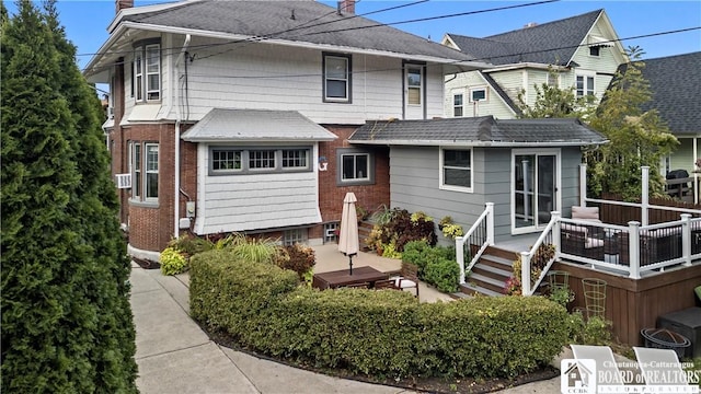 526 Central Ave, Dunkirk-City, NY 14048 - back of property with a chimney, a wooden deck, a shingled roof, and brick siding