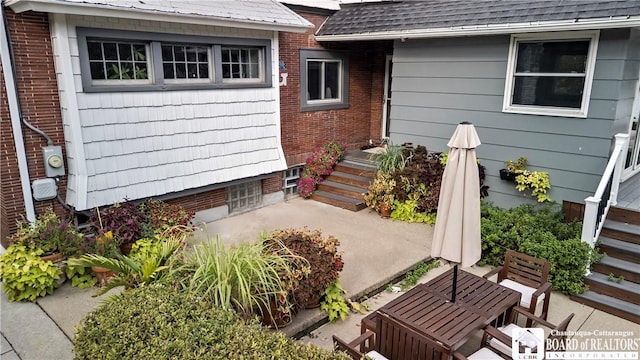 526 Central Ave, Dunkirk-City, NY 14048 - view of exterior entry featuring brick siding, roof with shingles, and a patio
