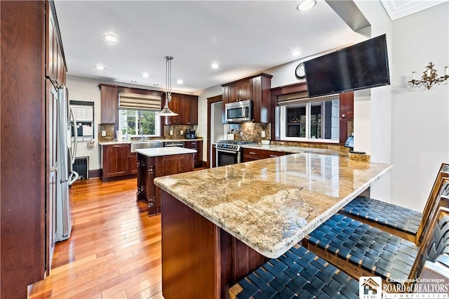 526 Central Ave, Dunkirk-City, NY 14048 - kitchen featuring stainless steel appliances, a peninsula, light wood-style floors, a breakfast bar area, and backsplash