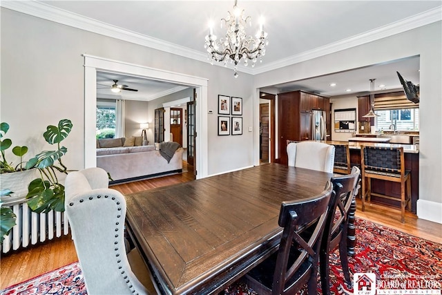 526 Central Ave, Dunkirk-City, NY 14048 - dining space with wood finished floors, a chandelier, ornamental molding, ceiling fan, and baseboards
