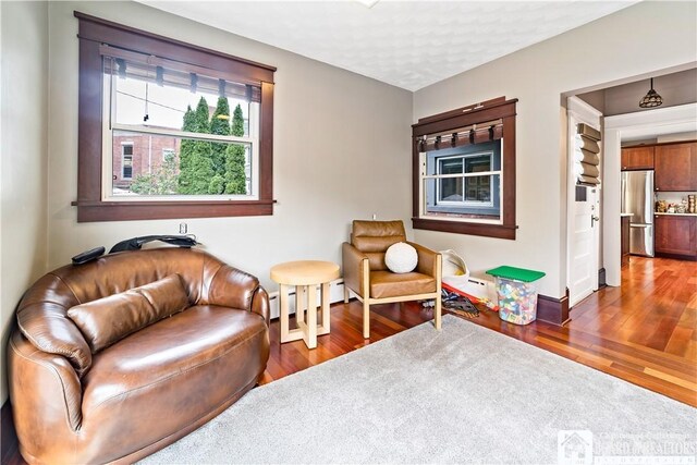 526 Central Ave, Dunkirk-City, NY 14048 - sitting room featuring wood finished floors, baseboards, and a baseboard heating unit