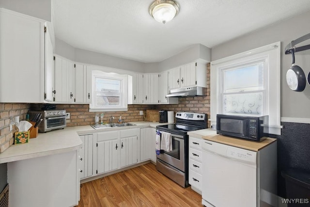 2902 Michigan Ave, Niagara Falls, NY 14305 - kitchen with stainless steel electric range, black microwave, under cabinet range hood, dishwasher, and healthy amount of natural light