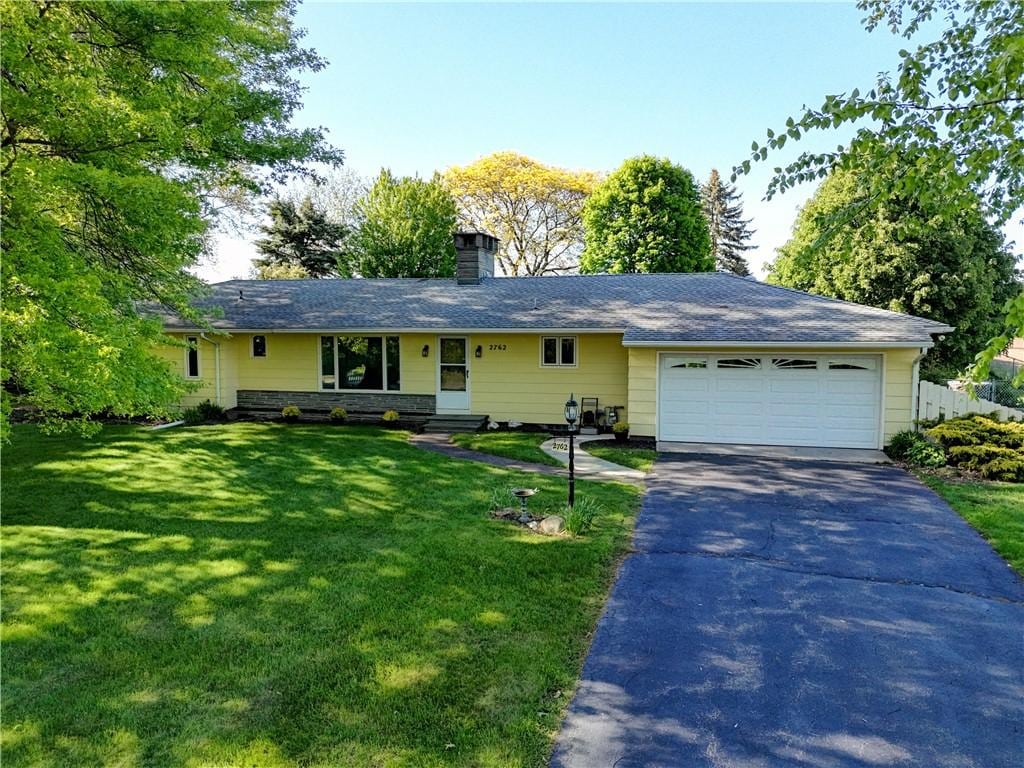 2762 Nichols St, Ogden, NY 14559 - ranch-style home with asphalt driveway, an attached garage, a front yard, a chimney, and entry steps