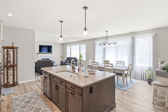 1167 Guinevere Dr, Greece, NY 14626 - kitchen featuring a sink, dishwasher, light wood-style floors, hanging light fixtures, and light stone countertops