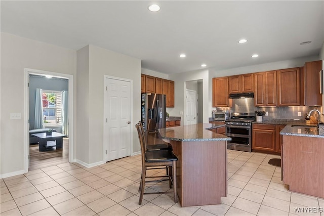 52 Apple Blossom Blvd, Lancaster, NY 14086 - kitchen featuring stainless steel appliances, under cabinet range hood, a sink, a kitchen island, and dark stone countertops