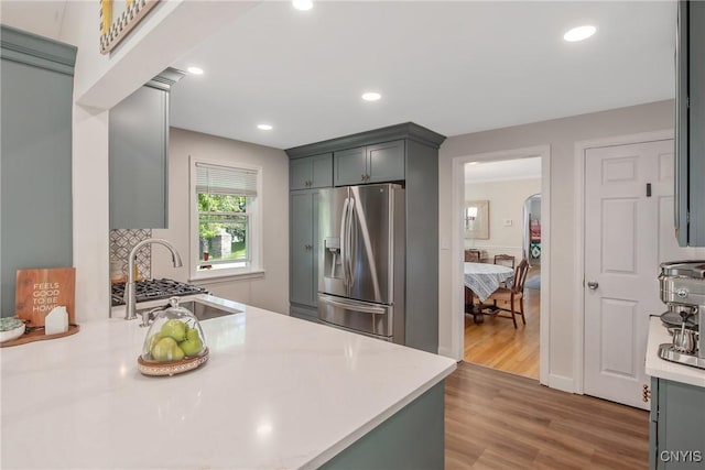 1607 Stolp Ave, Syracuse, NY 13207 - kitchen featuring stainless steel fridge with ice dispenser, light countertops, arched walkways, wood finished floors, and recessed lighting