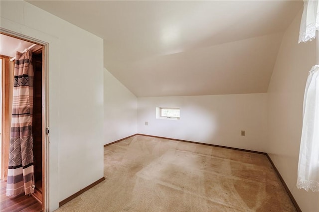 6695 Fisher Rd, Ontario, NY 14589 - additional living space featuring vaulted ceiling, baseboards, and carpet floors