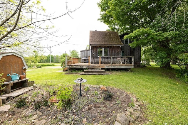 6695 Fisher Rd, Ontario, NY 14589 - rear view of property featuring a shingled roof, a wooden deck, and a lawn