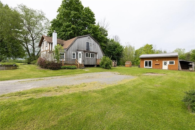 6695 Fisher Rd, Ontario, NY 14589 - view of grassy yard featuring a wooden deck, an outdoor structure, and driveway