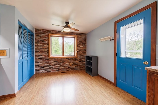 6695 Fisher Rd, Ontario, NY 14589 - foyer entrance with brick wall, light wood-type flooring, plenty of natural light, baseboards, and ceiling fan