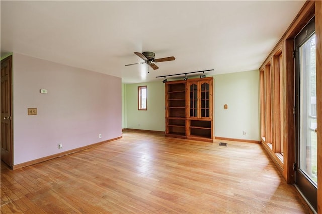 6695 Fisher Rd, Ontario, NY 14589 - empty room with rail lighting, light wood-style floors, ceiling fan, and baseboards