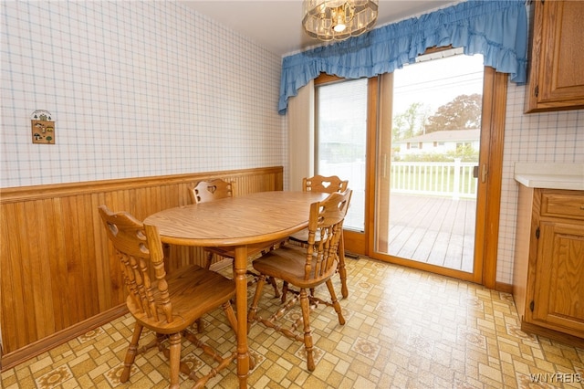 4314 Elmwood Ave, Hamburg, NY 14219 - dining space featuring wallpapered walls, brick patterned floors, a wainscoted wall, and wooden walls