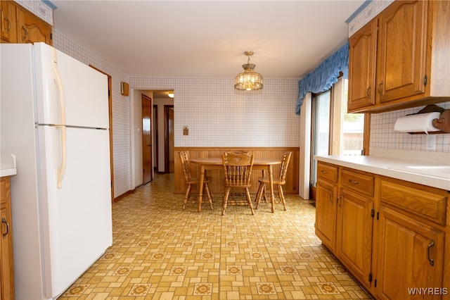 4314 Elmwood Ave, Hamburg, NY 14219 - kitchen featuring freestanding refrigerator, wallpapered walls, light countertops, light flooring, and a wainscoted wall