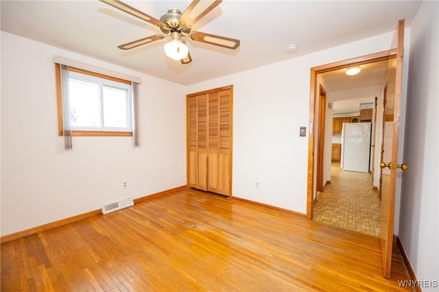 4314 Elmwood Ave, Hamburg, NY 14219 - unfurnished bedroom with freestanding refrigerator, light wood-style flooring, baseboards, a closet, and a ceiling fan