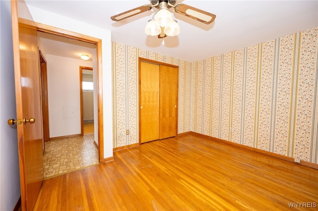 4314 Elmwood Ave, Hamburg, NY 14219 - unfurnished bedroom with wood finished floors, baseboards, wallpapered walls, a closet, and a ceiling fan