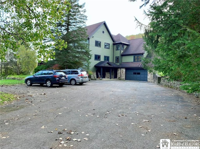 6753 Poverty Hill Rd, Ellicottville, NY 14731 - victorian-style house with driveway, stone siding, and a garage