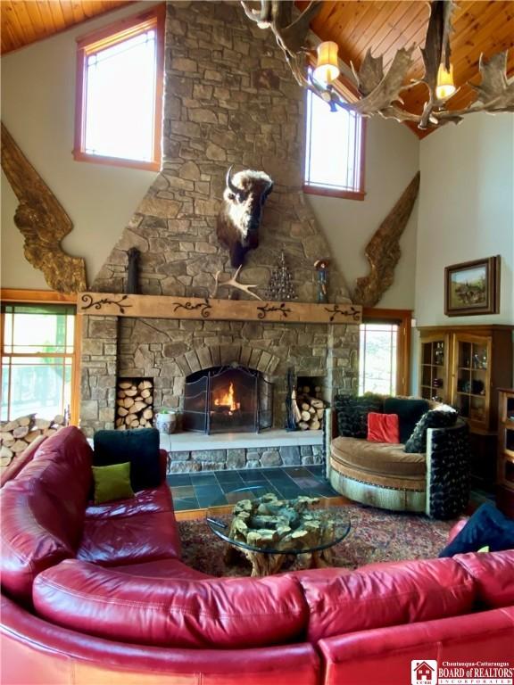 6753 Poverty Hill Rd, Ellicottville, NY 14731 - living room with wood ceiling, high vaulted ceiling, a stone fireplace, plenty of natural light, and a chandelier