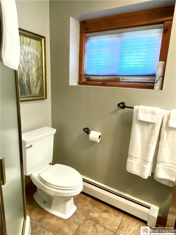 6753 Poverty Hill Rd, Ellicottville, NY 14731 - bathroom with a baseboard heating unit, toilet, tile patterned flooring, a shower stall, and baseboards