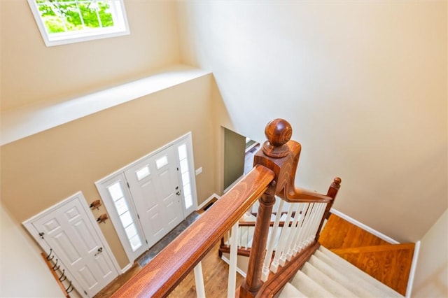 169 Watson Rd, Penfield, NY 14450 - stairs with wood finished floors, baseboards, and a towering ceiling