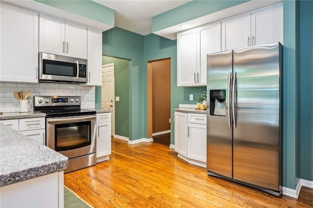 169 Watson Rd, Penfield, NY 14450 - kitchen featuring appliances with stainless steel finishes, backsplash, baseboards, and white cabinetry