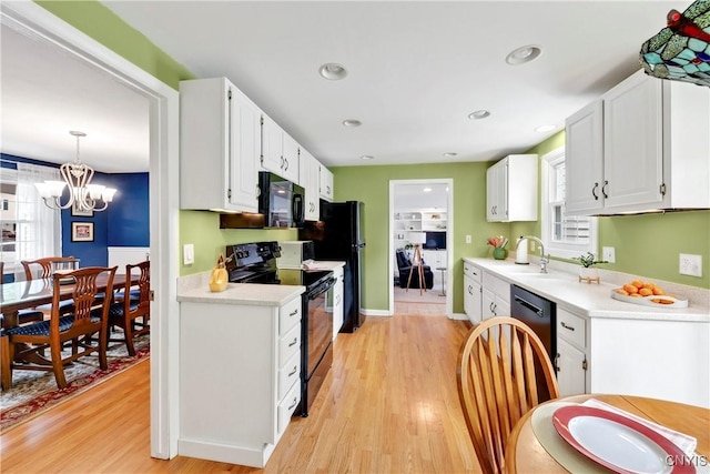 8260 Dexter Pkwy, Lysander, NY 13027 - kitchen featuring black appliances, light countertops, light wood-style flooring, white cabinetry, and recessed lighting