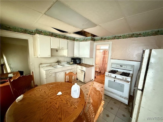 114 19th St, Buffalo, NY 14213 - kitchen featuring white appliances, a paneled ceiling, a sink, white cabinets, and light tile patterned flooring